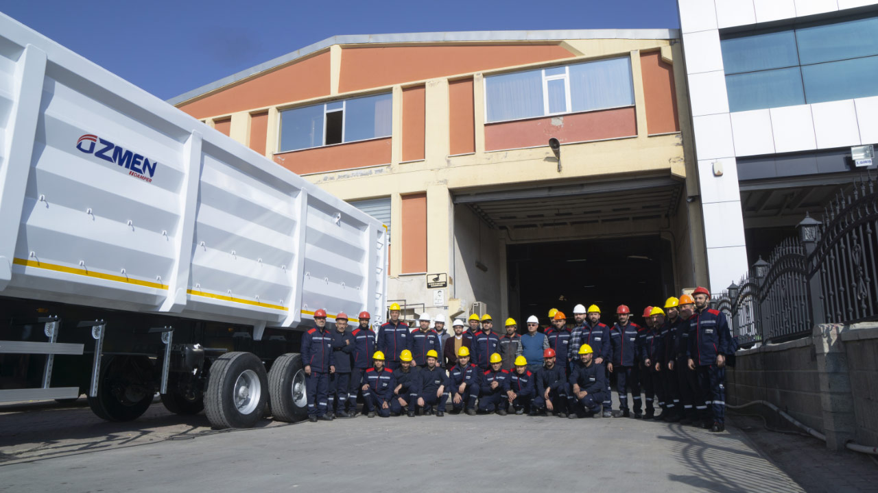 The hardhat crew at tipper bodybuilder Özmen Damper, next to a bright-white tipper made in extra tough Hardox® 500 Tuf steel.