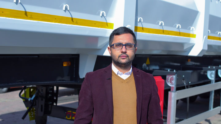 Mr. Mustafa Belgemen, second-generation manager of the family-run business Özmen Damper, in front of one of their extra tough and strong scrap tippers.