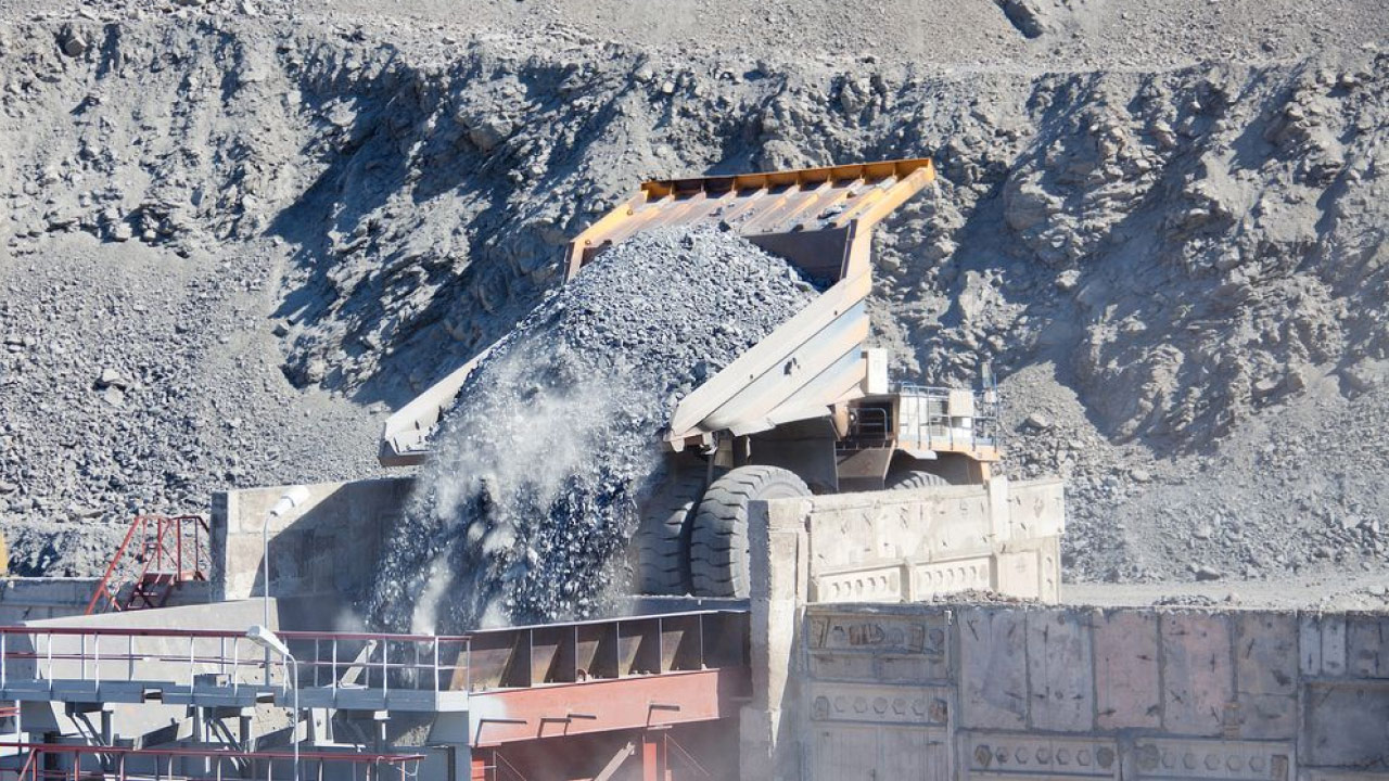 A mining site with a mining haul truck dumping a load of abrasive rocks.